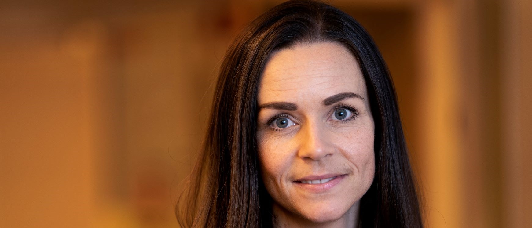 Lina Bergman, förlossningsöverläkare vid Sahlgrenska Universitetssjukhuset står framför en orange bakgrund. Det är en närbild som visar Lisas ansikte.