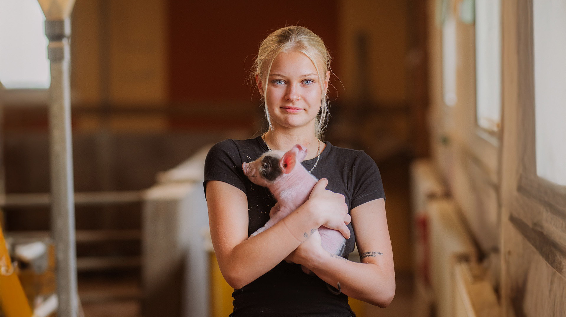 Elev håller griskulting i famnen