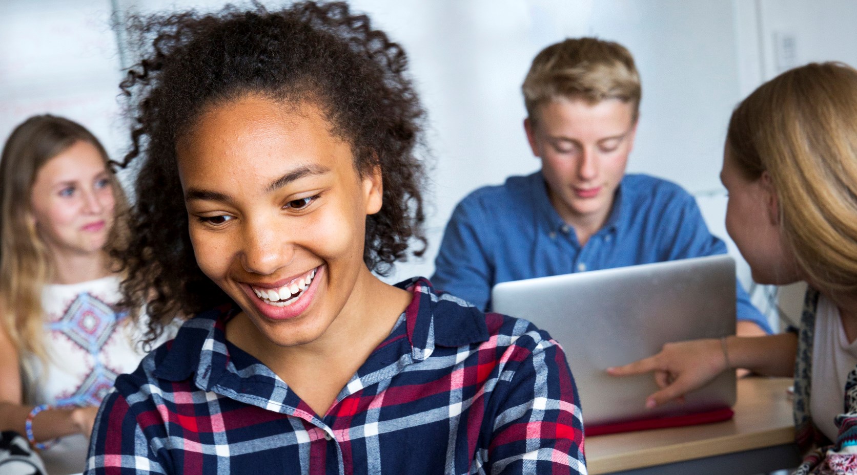 Teenagers with laptop in classroom